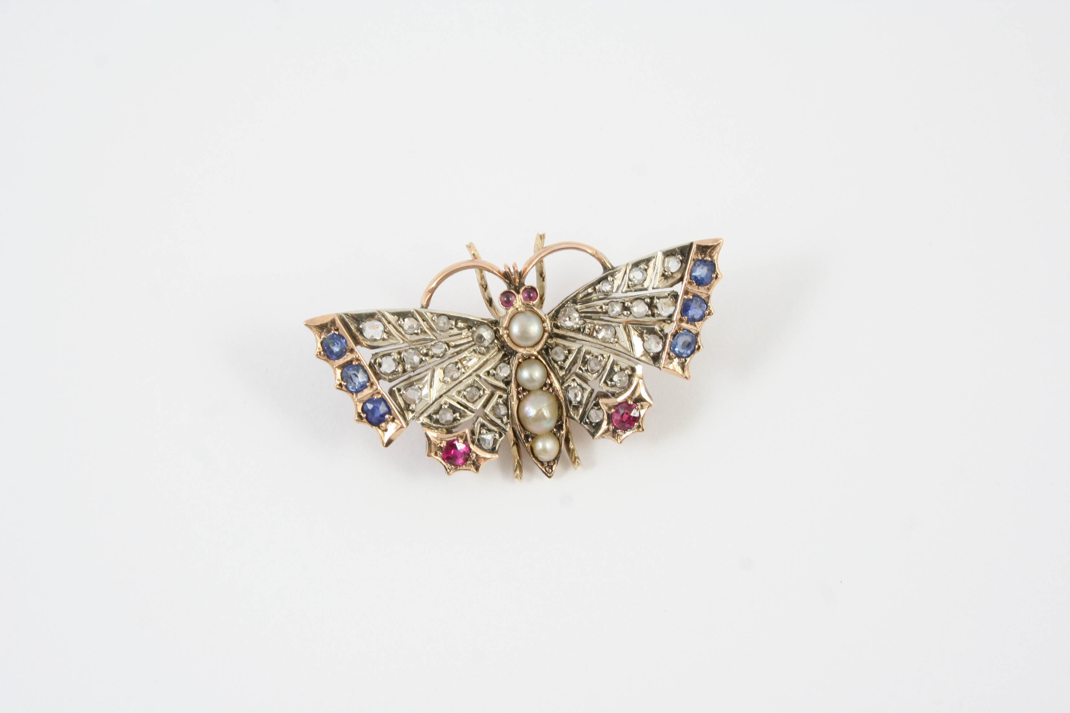 A VICTORIAN DIAMOND AND GEM SET BUTTERFLY BROOCH the body set with graduated half pearls, the