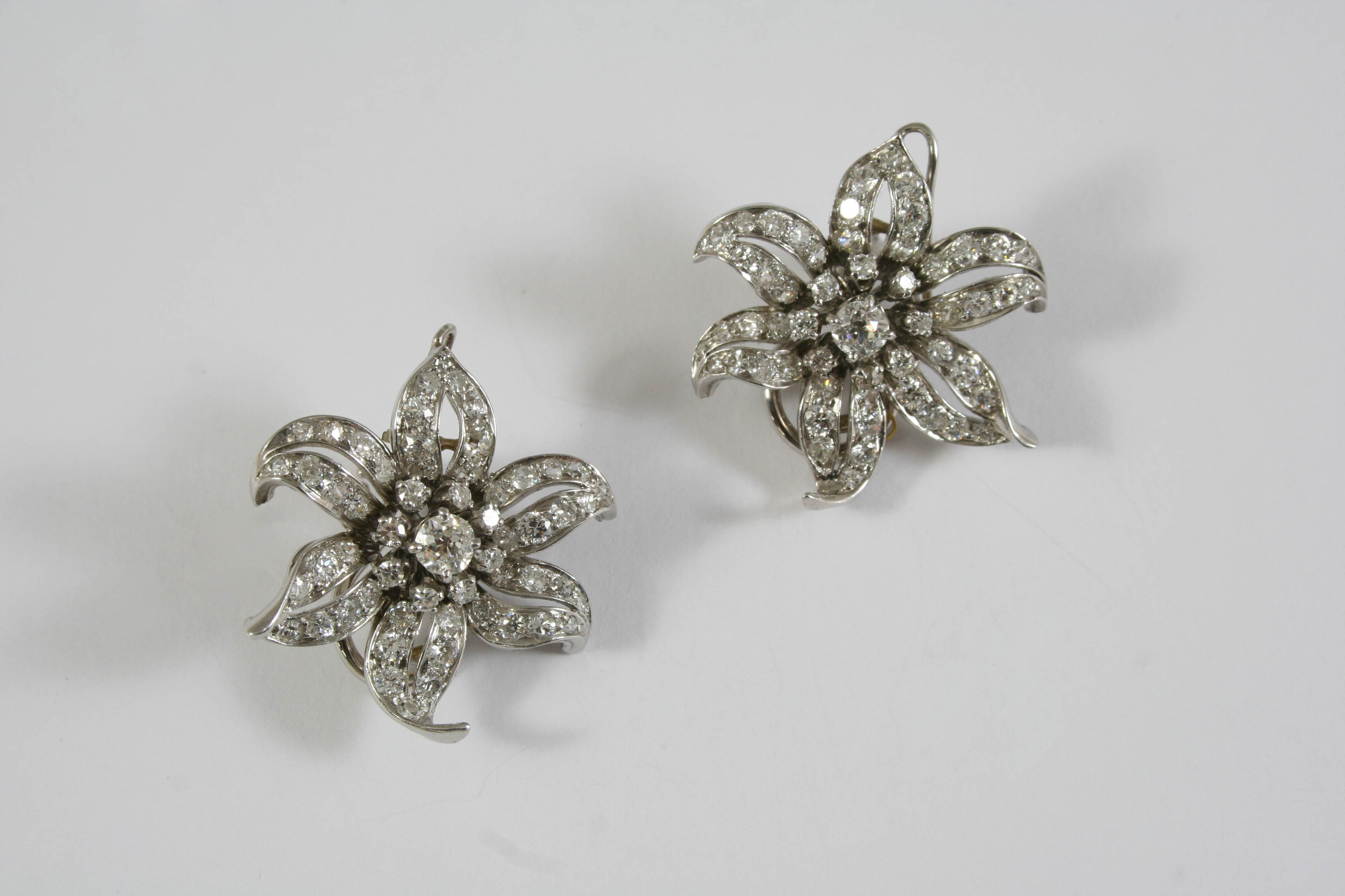 A PAIR OF DIAMOND FLOWERHEAD CLIP EARRINGS set overall with graduated circular-cut diamonds, 3cm