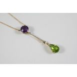 AN EDWARDIAN SUFFRAGETTE PENDANT the pear-shaped peridot is suspended from a foliate design set with