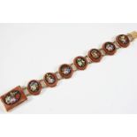 A VICTORIAN MOSAIC BRACELET formed with seven oval-shaped foliate mosaics set in sandstone to a