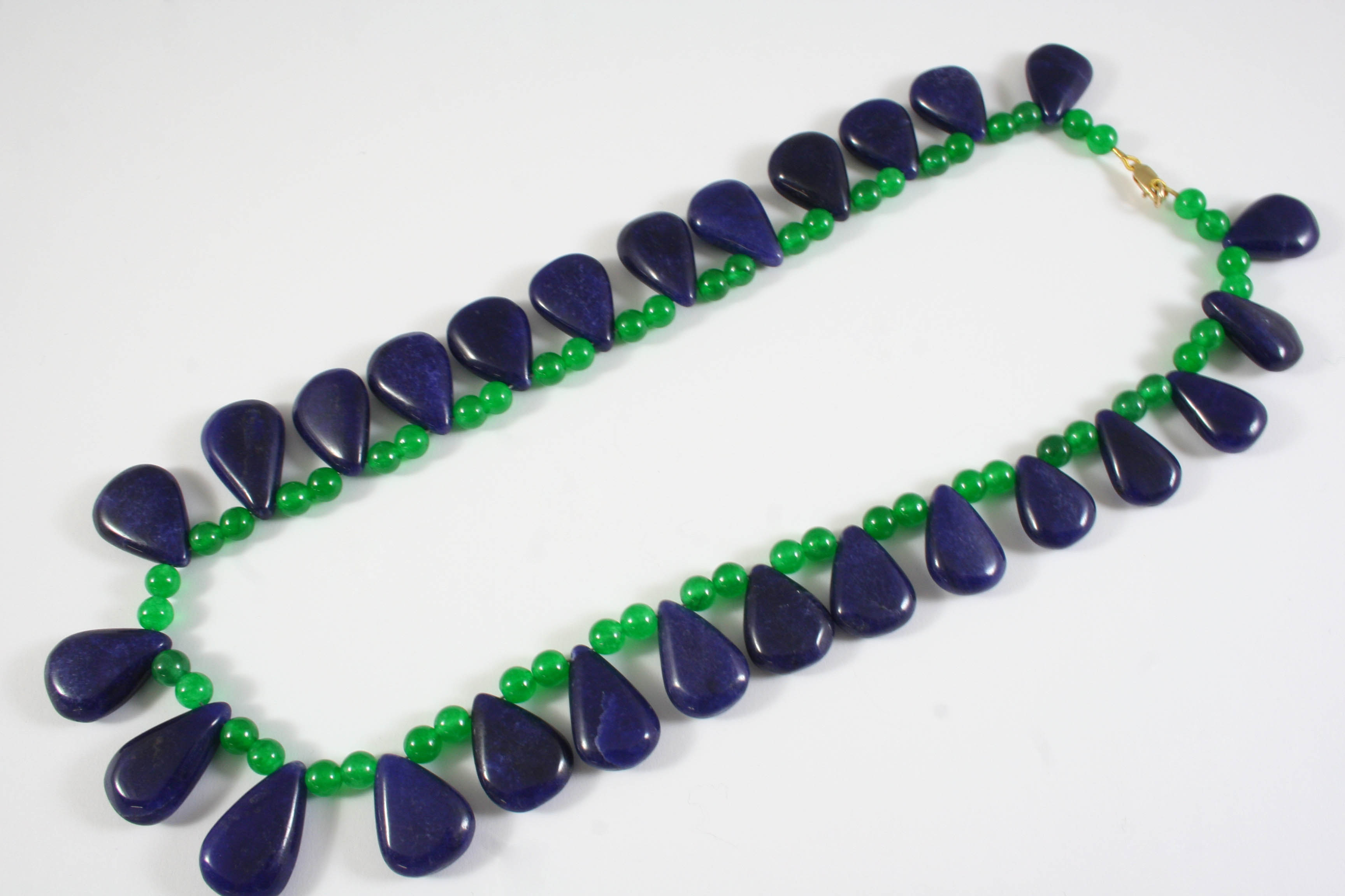 A SAPPHIRE AND EMERALD NECKLACE the emerald bead necklace suspends sapphire pear-shaped drops,