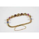 A GOLD AND GEM SET BRACELET the gold curb link bracelet is mounted with assorted graduated oval-