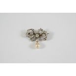 A VICTORIAN DIAMOND AND PEARL BROOCH the scrolling bow design is set with graduated old circular-cut