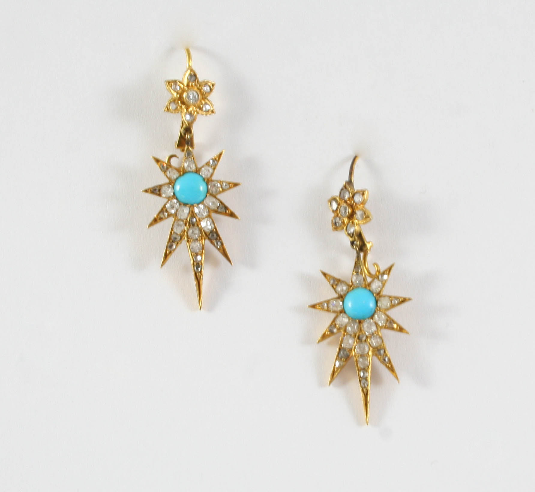 A PAIR OF TURQUOISE AND DIAMOND SET DROP EARRINGS of star design, each centred with a circular