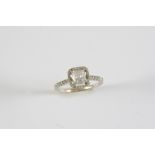 A DIAMOND CLUSTER RING the cushion-shaped diamond is set within a surround of circular-cut diamonds,