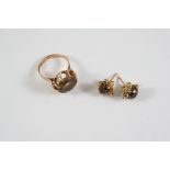 A SMOKY QUARTZ SINGLE STONE RING the circular smoky quartz is set in gold, size M, together with a
