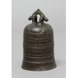 CHINESE BRONZE BELL, of archaistic form, a twin dragon loop handle, ruyi lappet and other banded