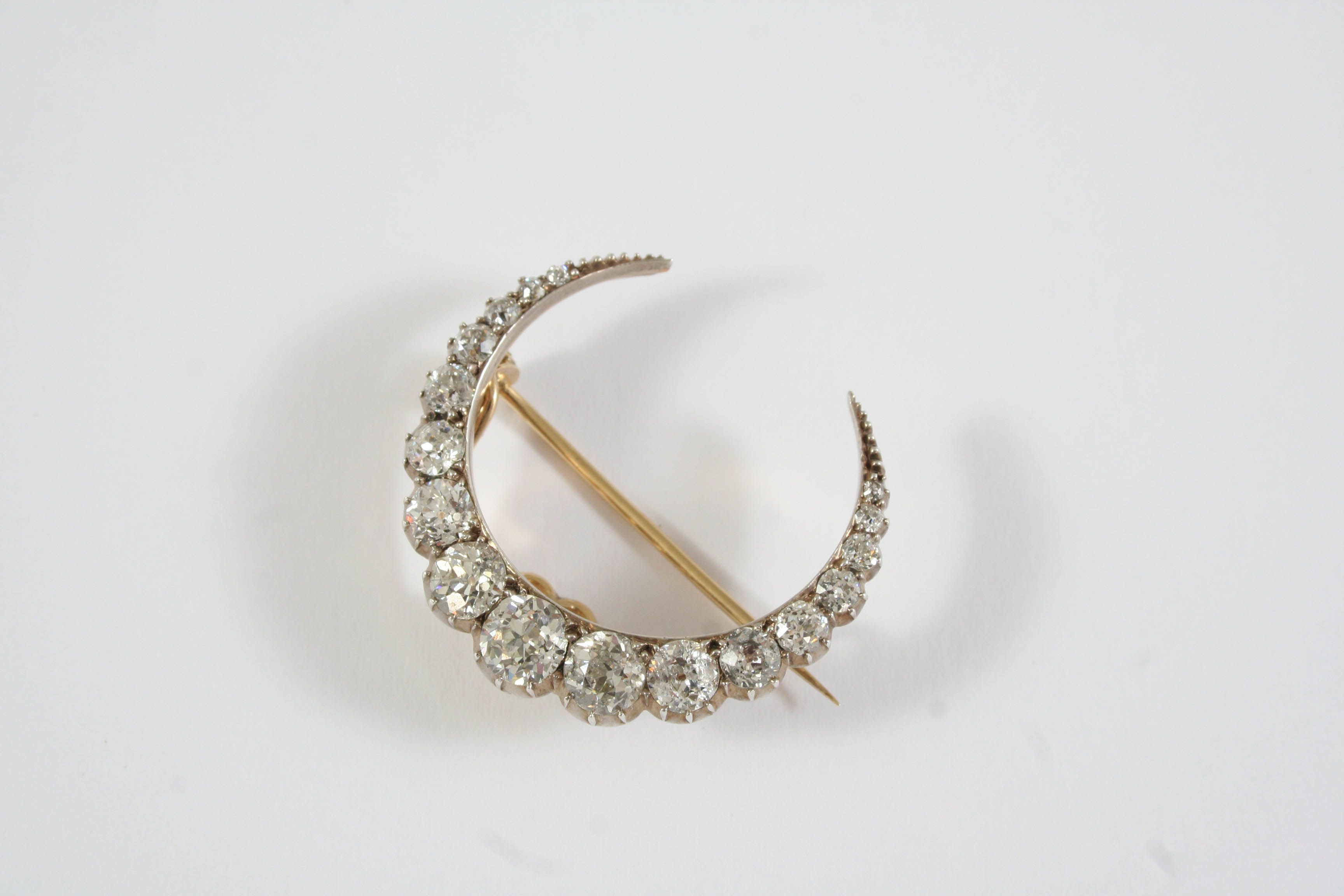 A VICTORIAN DIAMOND CLOSED CRESCENT BROOCH formed with graduated old brilliant-cut diamonds, in