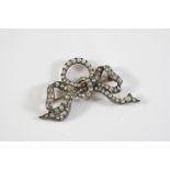A VICTORIAN DIAMOND BOW BROOCH mounted with graduated old cut diamonds in silver and backed in gold,