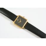 A LADY'S 18CT GOLD WRISTWATCH BY BAUME & MERCIER with signed black square -shaped dial, cabochon