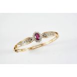 A RUBY, DIAMOND AND GOLD HALF HINGED BANGLE the oval-shaped ruby is set within a surround of