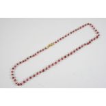 A RUBY BEAD NECKLACE mounted with faceted ruby beads on a gold chain, 38.5cm long