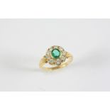 AN EMERALD AND DIAMOND CLUSTER RING the oval-shaped emerald is set within a surround of nine