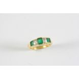 AN EMERALD AND DIAMOND FIVE STONE RING the rectangular-shaped emerald is set with two square-