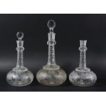 PAIR OF GLOBE AND SHAFT DECANTERS, the faceted necks with a knop, the body engraved with fruiting
