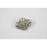 A VICTORIAN DIAMOND BROOCH the openwork foliate design is set with graduated old circular diamonds