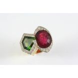 A TOURMALINE AND DIAMOND DOUBLE CLUSTER RING mounted with a red and green tourmaline each within a