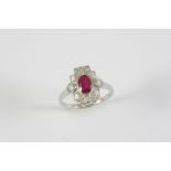 A RUBY AND DIAMOND CLUSTER RING the oval-shaped ruby is set within a surround of six baguette-cut