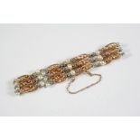 A 15CT GOLD, PLATINUM AND PEARL SET BRACELET formed with gold oval shaped openwork links and