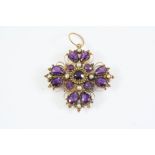 A VICTORIAN AMETHYST AND GOLD CRUCIFORM PENDANT mounted with pear-shaped and circular-cut