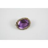 AN AMETHYST AND PEARL BROOCH the oval-shaped amethyst is set within a surround of half pearls, in