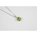 A PERIDOT AND DIAMOND PENDANT the flowerhead design is set with four heart-shaped peridots and a