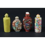 FOUR CHINESE PORCELAIN SNUFF BOTTLES, to include one cast with eight dragons chasing balls,