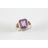 AN AMETHYST AND CITRINE RING the cut cornered rectangular-shaped amethyst is set with two heart-