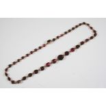 A GEORGIAN ALMANDINE GARNET RIVIERE NECKLACE formed with graduated oval-shaped garnets in gold