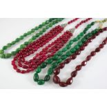 TWO INDIAN CARVED EMERALD NECKLACES together with an Indian faceted ruby necklace and a three row