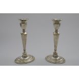 A PAIR OF EARLY 20TH CENTURY CANDLESTICKS on oval bases with tapering oval columns, urn-shaped