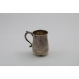 A GEORGE III SMALL IRISH MUG with a tucked-in base and a leaf-capped, scroll handle, initialled "