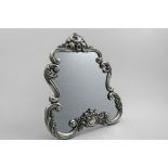 A MID 19TH CENTURY AUSTRO-HUNGARIAN DRESSING TABLE MIRROR with large, embossed scroll borders, a