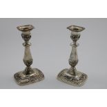 A PAIR OF EDWARDIAN CANDLESTICKS on rounded oblong bases, decorated with part-fluting and shells,