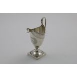 A RARE GEORGE III HELMET CREAM JUG with a square pedestal foot and engraved decoration,