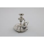 A VICTORIAN TAPERSTICK on four stubby scroll feet with a fluted circular base, drip-pan and