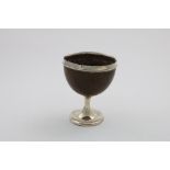 A GEORGE IV / WILLIAM IV MOUNTED COCONUT GOBLET on a circular pedestal foot, with a large, plain