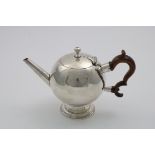 A RARE GEORGE I SCOTTISH TEA POT of plain bullet form on a circular pedestal foot, with a straight