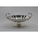 AN EARLY 19TH CENTURY TWO-HANDLED FRUIT DISH on a shap-ed oval pedestal foot, with a gadrooned