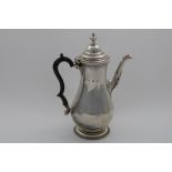 AN EDWARDIAN COFFEE POT of baluster form with gadrooned borders, a domed cover & a knop finial, by