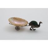 AN EDWARDIAN NOVELTY PIN CUSHION in the form of an emu pulling a mother of pearl-mounted cart, by