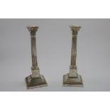 A PAIR OF MID 20TH CENTURY CANDLESTICKS with fluted columns and stepped, square plinth bases, with