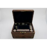 A VICTORIAN BRASS BOUND ROSEWOOD DRESSING CASE fitted with various mounted cut-glass bottles/jars, a