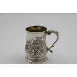 A GEORGE III BALUSTER MUG on a spreading foot, embossed decoration, and a leaf-capped scroll handle,