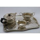 A LATE VICTORIAN THREE-PIECE TEA SET with shallow circular part-fluted bodies, decorated with a "