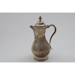 A GEORGE III BALUSTER HOT WATER JUG with a decorative angular spout, gadrooned borders and a domed