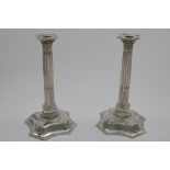 A PAIR OF GEORGE II COLUMN CANDLESTICKS on domed and shaped cruciform bases with an applied stiff