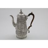 A GEORGE IV EMBOSSED COFFEE POT of tapering form with a tucked-in base, decorated with vignettes