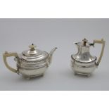 AN EARLY 20TH CENTURY TEA POT & MATCHING HOT WATER JUG with gadrooned borders, ball feet and ivory