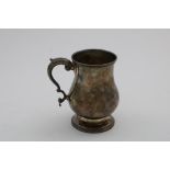AN EARLY 19TH CENTURY UNASCRIBED, BALUSTER MUG ON A SPREADING FOOT with a leaf-capped scroll handle,